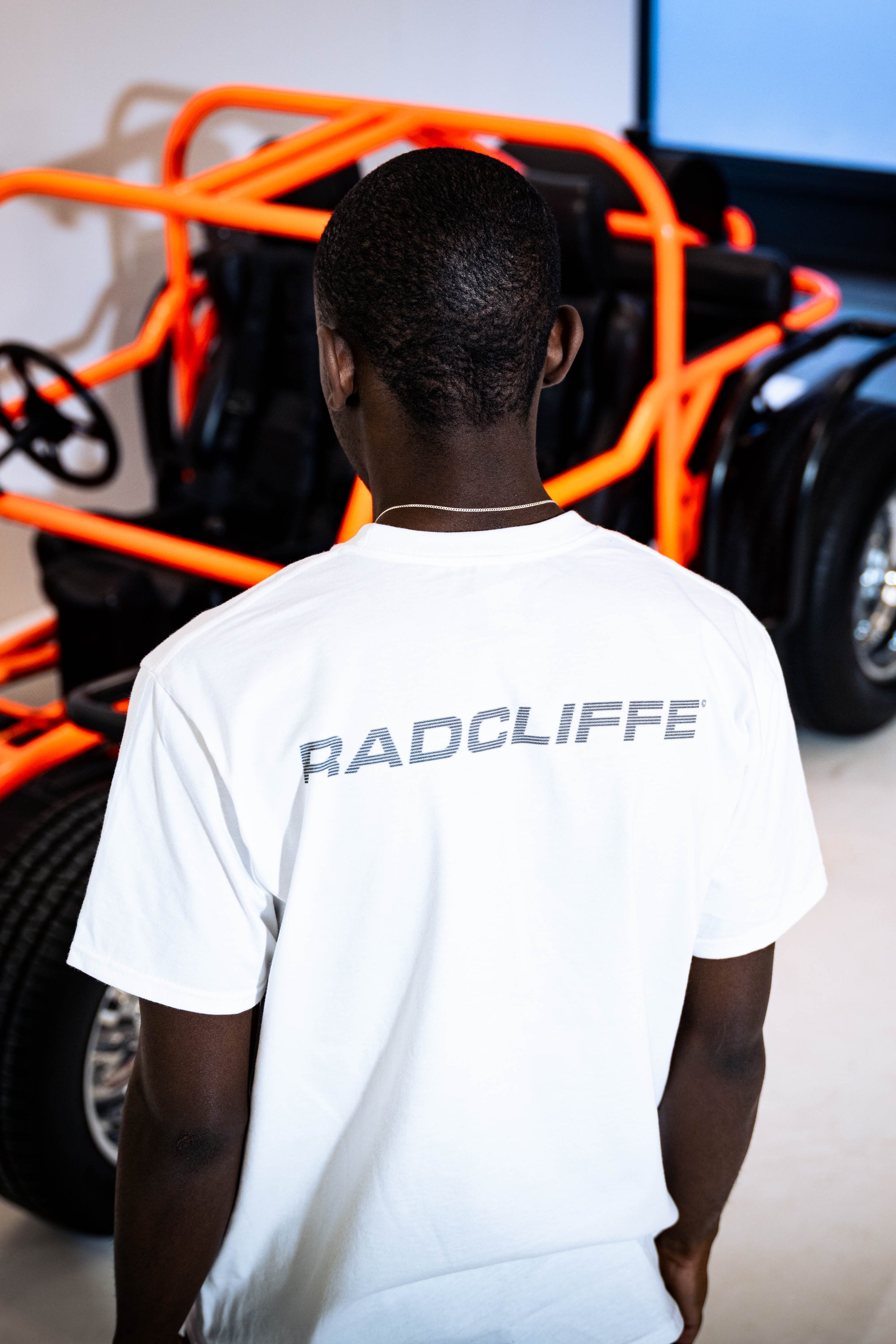 Radcliffe car-sketch tee — front, seated